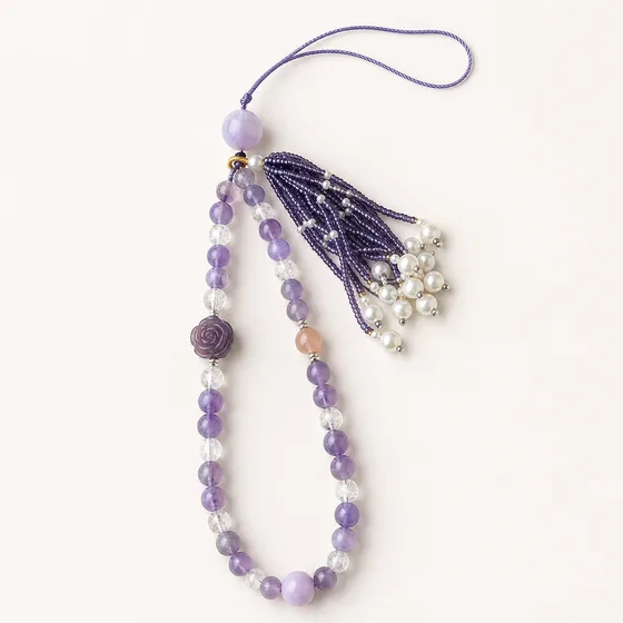 Amethyst, a large kunzite bead and rose quartz, with a purple fluorite rose and a beaded tassel.