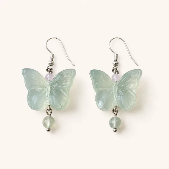 A carved jade butterfly, rose quartz above it and jade beads below.
